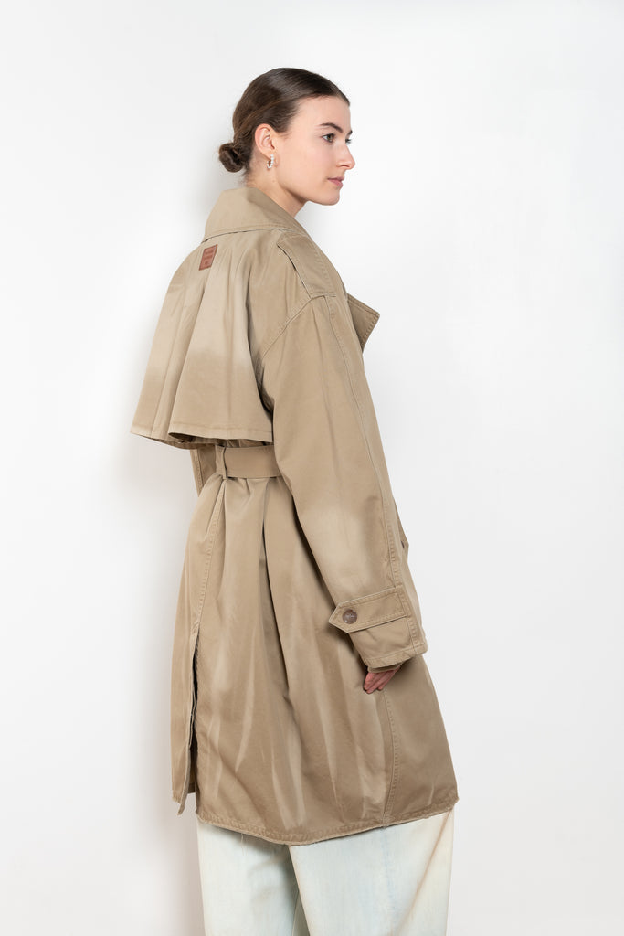 The Belted Trench Coat by Acne Studios is a cotton twill trench with a garment-dyed finish and an Acne Studios logo patch at the centre back