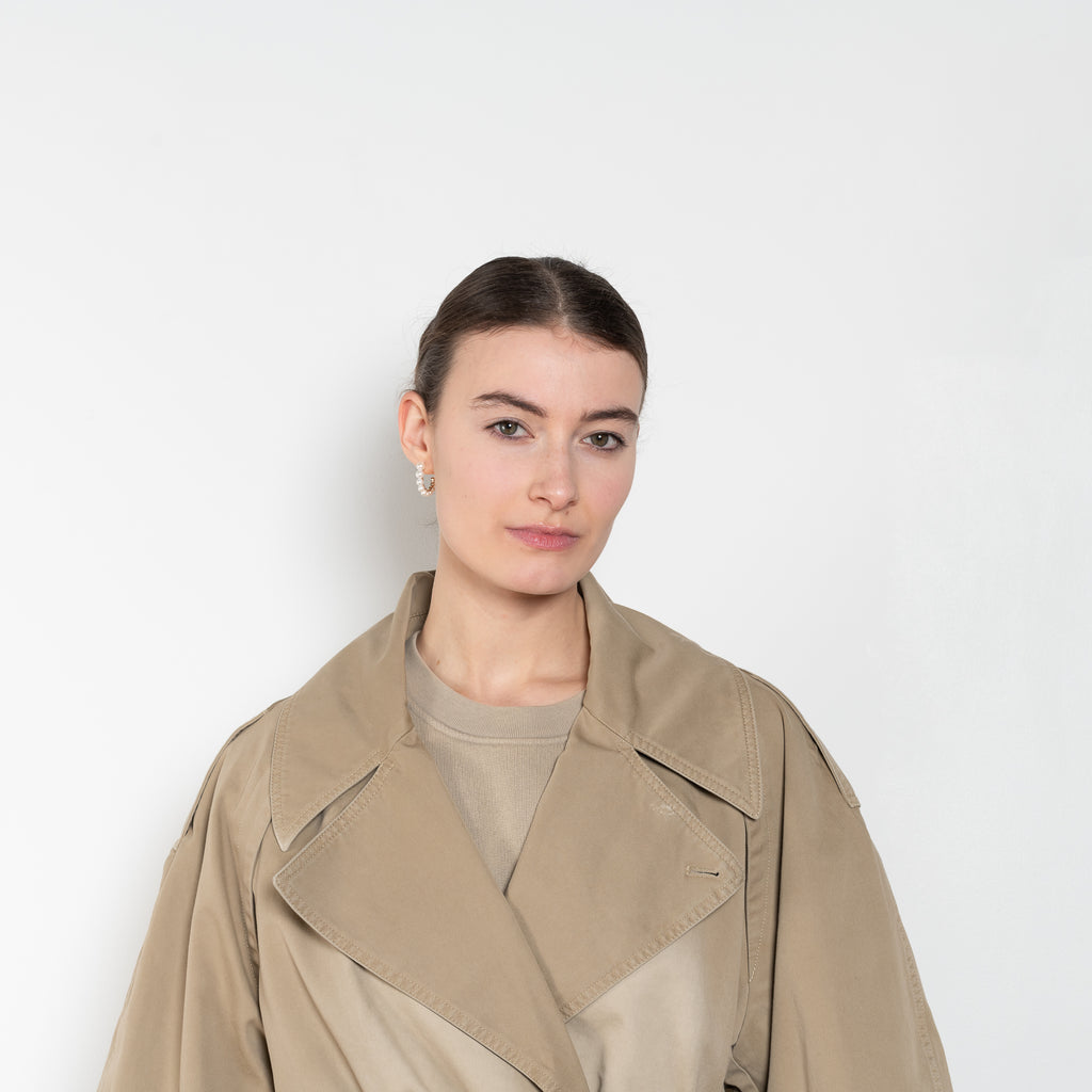 The Belted Trench Coat by Acne Studios is a cotton twill trench with a garment-dyed finish and an Acne Studios logo patch at the centre back