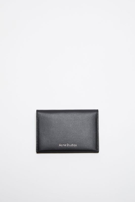 The Folded Leather Wallet by Acne Studios features a folded opening with card slot compartments, crafted from smooth leather and detailed with an Acne Studios logo on the front