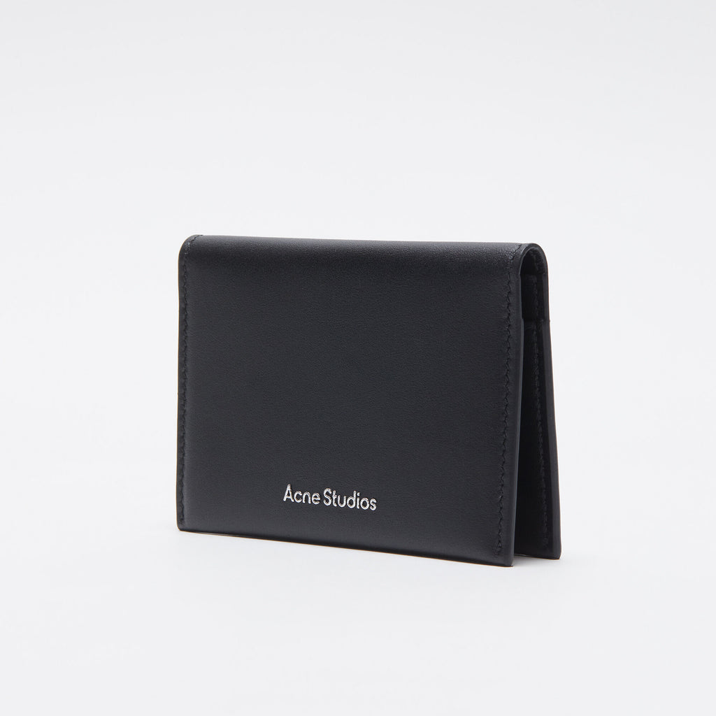 The Folded Leather Wallet by Acne Studios features a folded opening with card slot compartments, crafted from smooth leather and detailed with an Acne Studios logo on the front