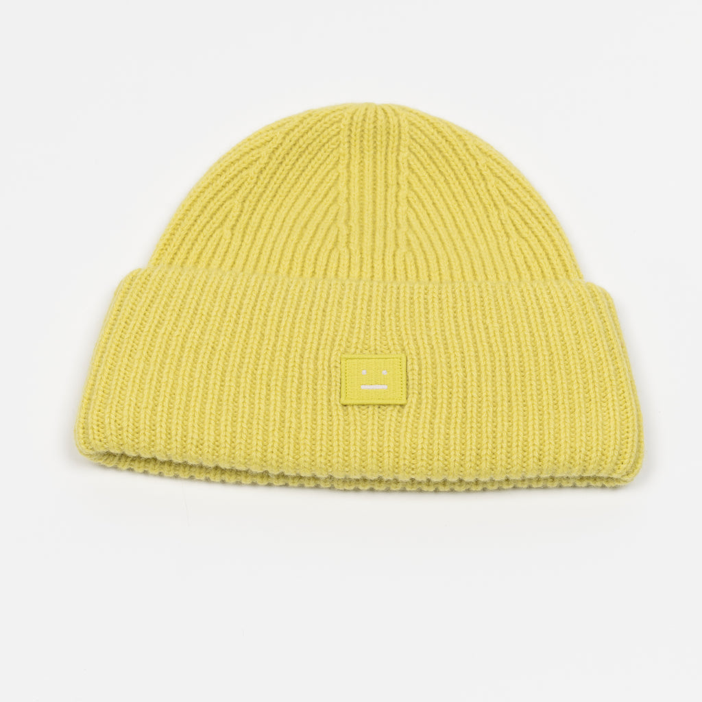 The Small Face Logo Beanie by Acne Studios features a small embroidered face logo patch and ribbed detailing, crafted from chunky wool.