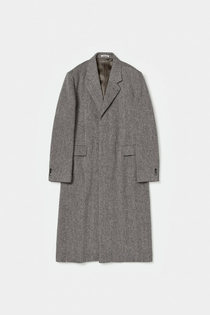 The Chesterfield Coat by Auralee is a lightweight and elegant tweed coat characterized by the crisp texture of British wool and the luxurious, voluminous fibers of alpaca