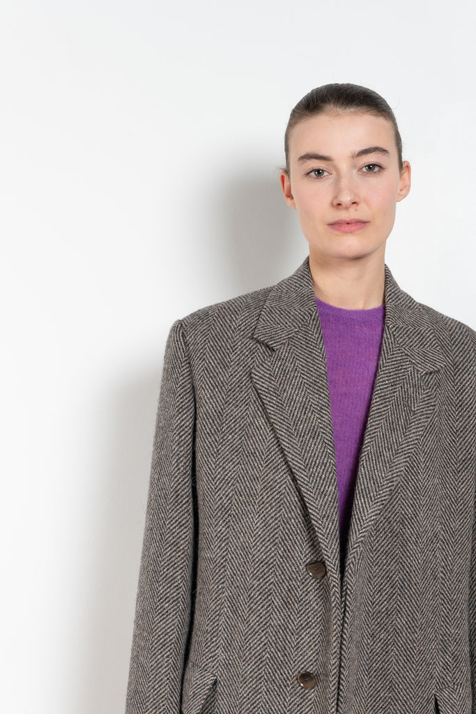 The Chesterfield Coat by Auralee is a lightweight and elegant tweed coat characterized by the crisp texture of British wool and the luxurious, voluminous fibers of alpaca