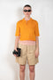 The Gauze Polo by Auralee is a cropped polo top in a vibrant orange sheer cotton jersey