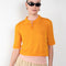 The Gauze Polo by Auralee is a cropped polo top in a vibrant orange sheer cotton jersey