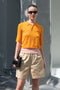 The Gauze Polo by Auralee is a cropped polo top in a vibrant orange sheer cotton jersey