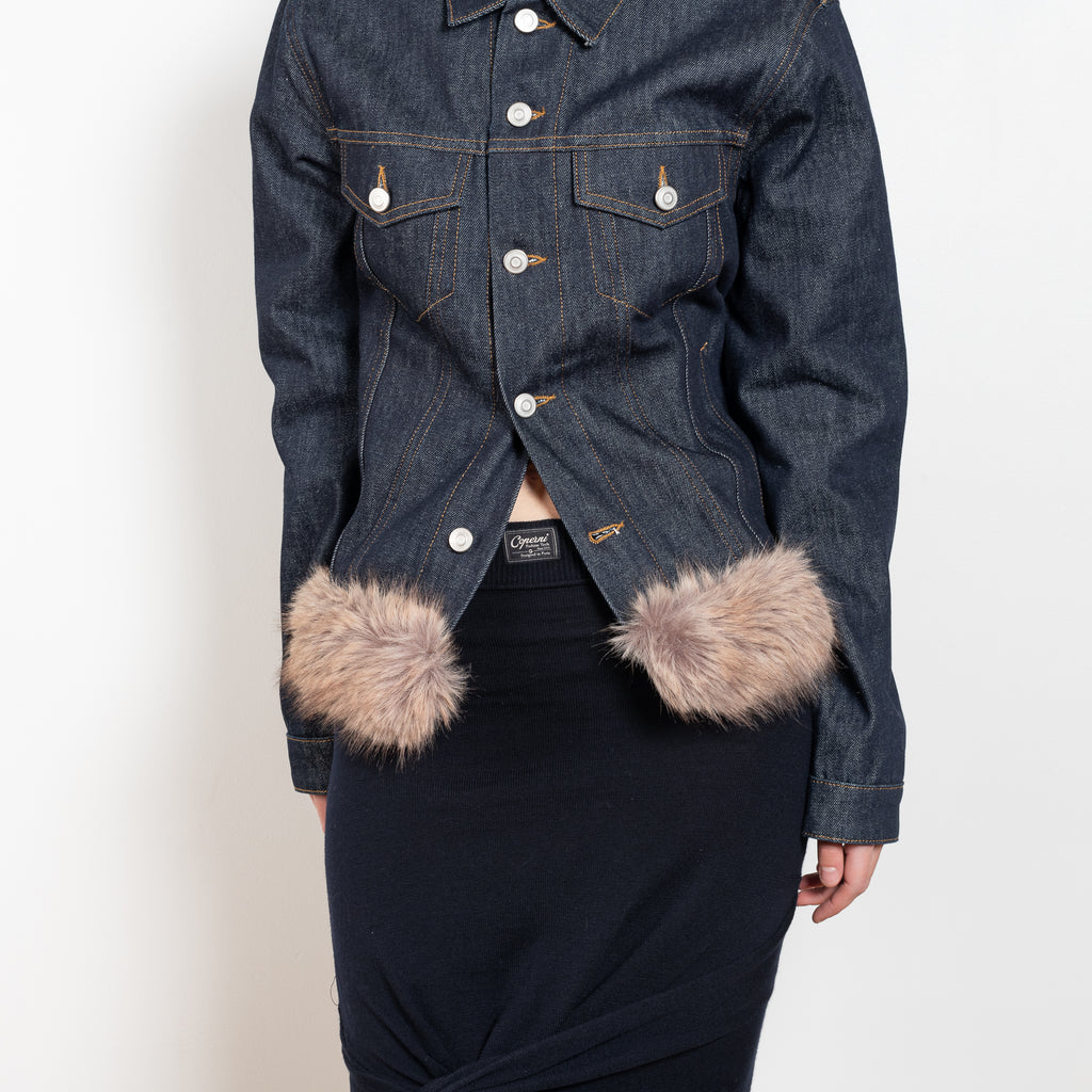 The Faux Fur Hem Denim Jacket by Coperni is a denim jacket with a faux fur waistband at the front