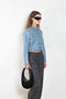 The Workwear Denim Jacket by Coperni is a cropped denim jacket with a zip closure and minimal details