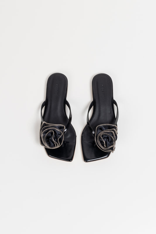 The Zip Flower Flip Flop by Coperni is a signature mule with a kitten heel and a Coperni Logo 