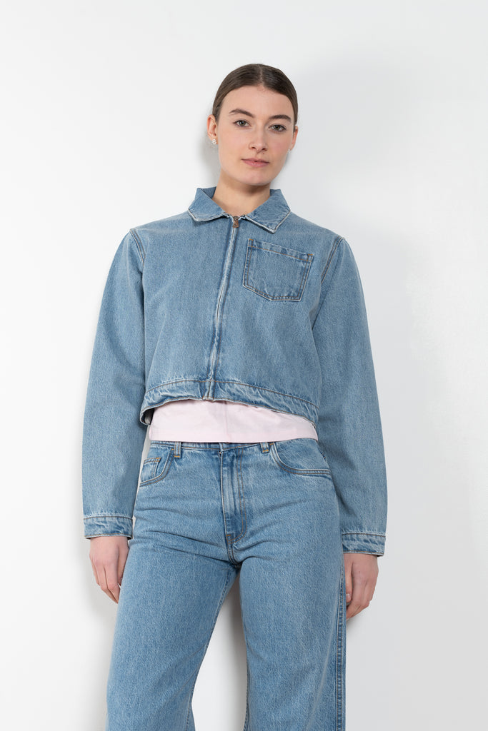 The Workwear Denim Jacket by Coperni is a cropped denim jacket with a zip closure and minimal details