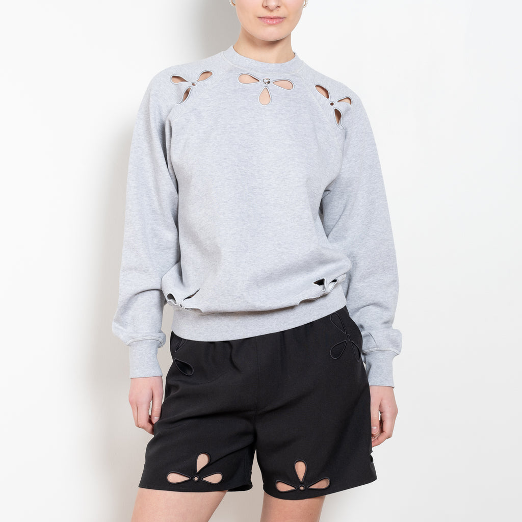 The Petal Embroidered Sweater by Coperni is a relaxed sweater with a small Coperni logo and seasonal petal cut-outs