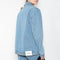 The Studded Denim Jacket by Coperni is a loose denim jacket with studded details and a front button closure