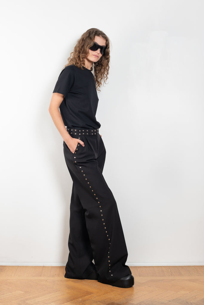 The Studded Tailored Trouser by Coperni is a mid rise trouser with a long wide leg and allover studs on the side and waistline