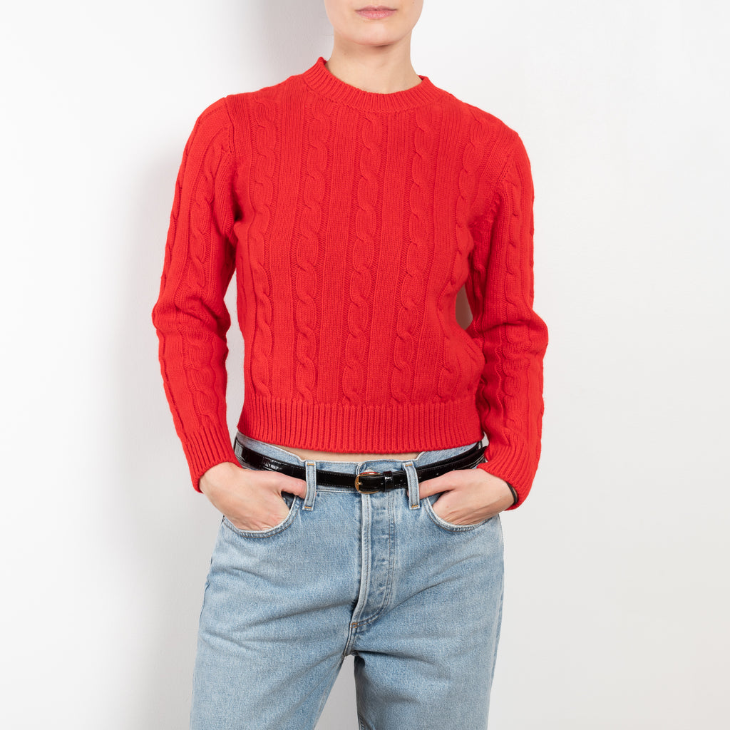 The Carrow Cable Crewneck is a crewneck sweater with a signature cable pattern and a shorter fitted silhouette