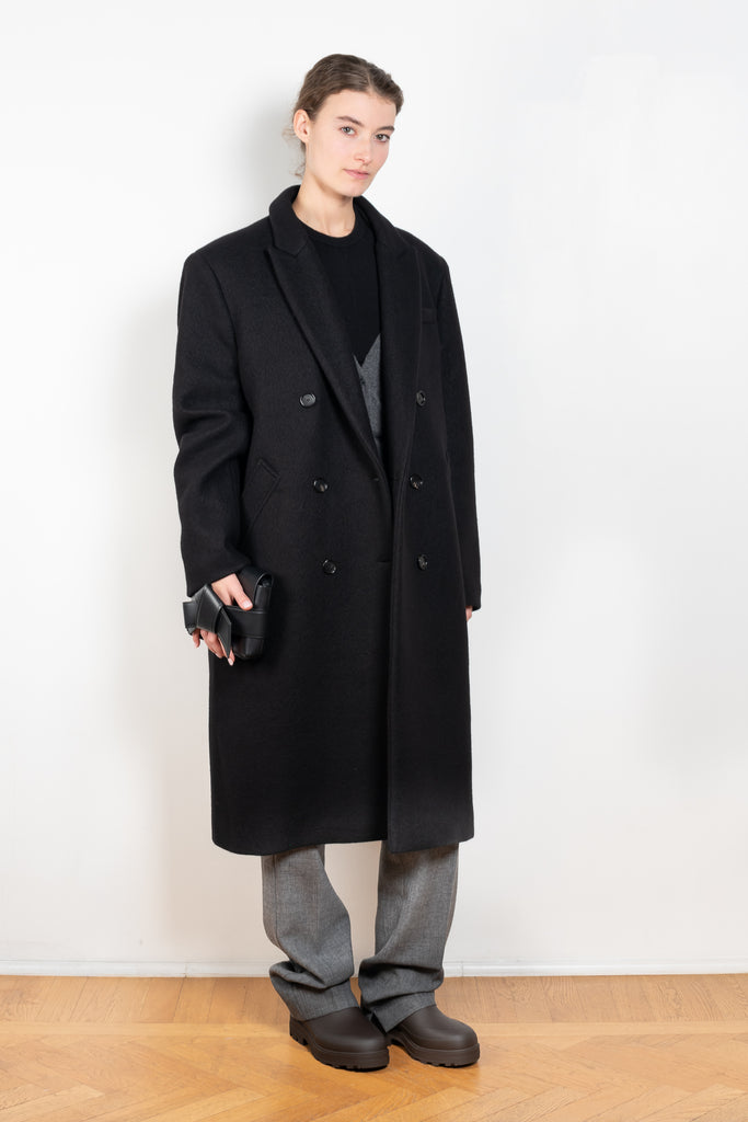 The Double Breasted Coat by KASSL Editions is a long coat crafted from boiled wool with classic men coat inspired detailing