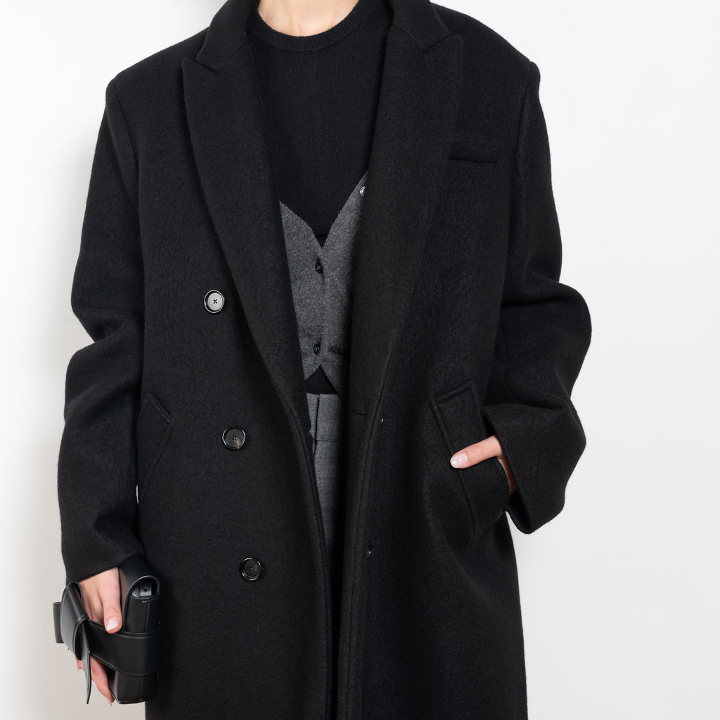 The Double Breasted Coat by KASSL Editions is a long coat crafted from boiled wool with classic men coat inspired detailing