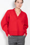 The V-Sweater by Kassl Edtions is crafted from boiled heavy merino wool in a vibrant red color.