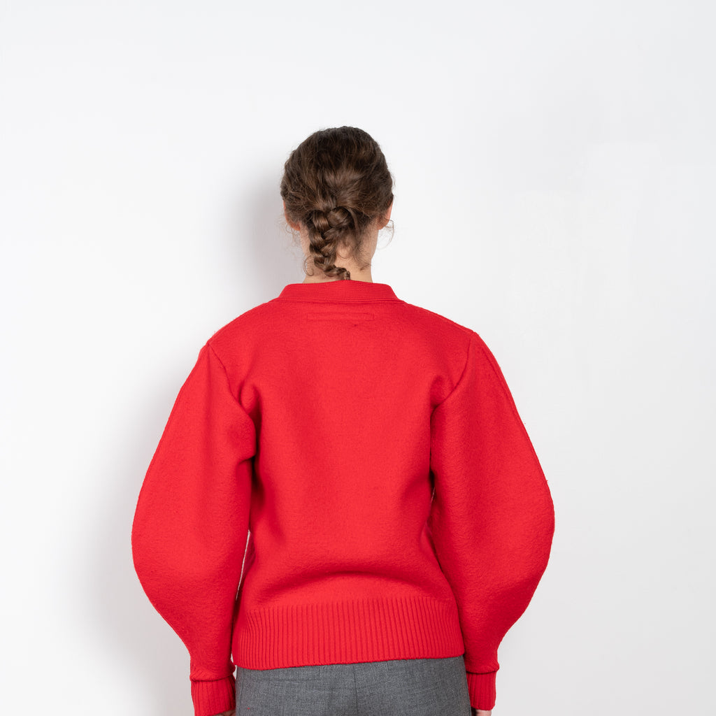 The V-Sweater by Kassl Edtions is crafted from boiled heavy merino wool in a vibrant red color.