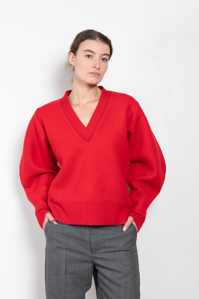 The V-Sweater by Kassl Edtions is crafted from boiled heavy merino wool in a vibrant red color.