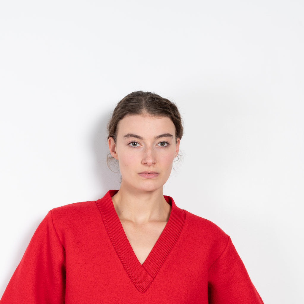 The V-Sweater by Kassl Edtions is crafted from boiled heavy merino wool in a vibrant red color.