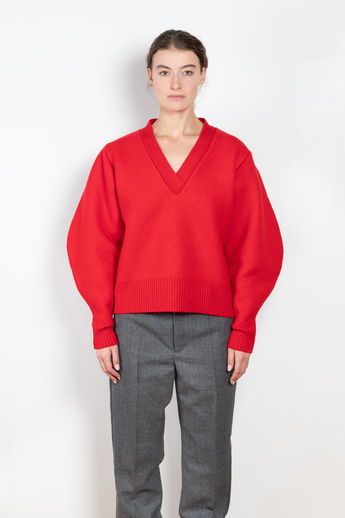 The V-Sweater by Kassl Edtions is crafted from boiled heavy merino wool in a vibrant red color.