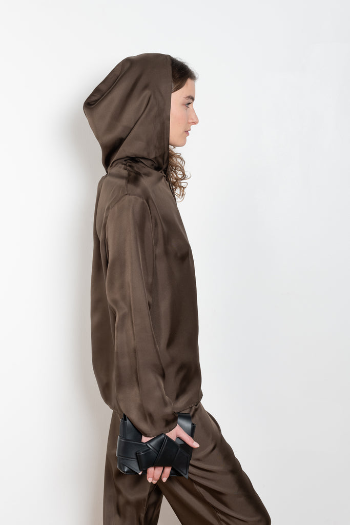 The Nuka Top by Loulou Studio is a hooded top with a relaxed fit in a fluid and lightweight summer silk