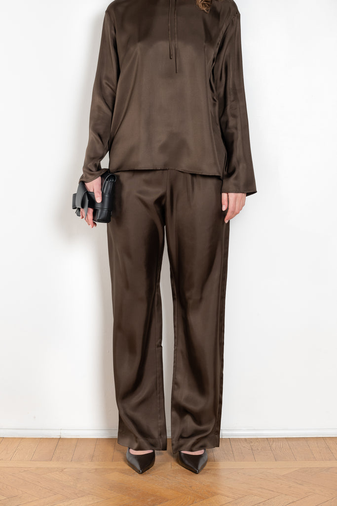 The Alera Trouser by Loulou Studio is a trouser with a relaxed fit in a fluid and lightweight summer silk
