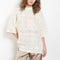 The Antila Top by Loulou Studio is a lace stitch top with a loose fit and wide short sleeves