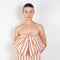 The Dance Floor Gown by Nackiye is a striped bustier dress with a front bow and a back slit