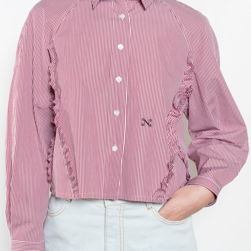 The Moshi Moshi Top by Nackiye is a buttoned up tailored shirt with front and back ruffles running down along the sides