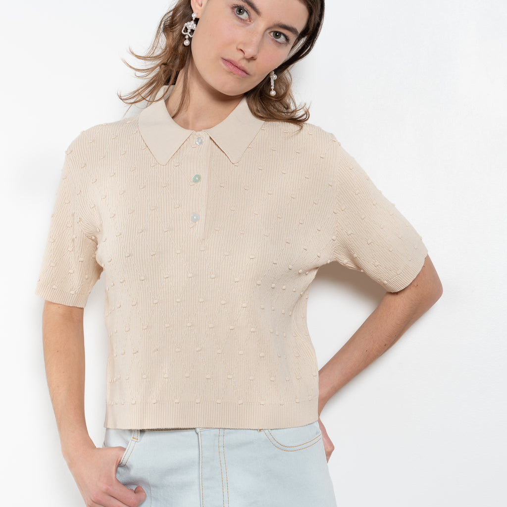 The Polo Swing Top by Nackiye is a structured short sleeved, collared knit with baubles and diamond stitching.