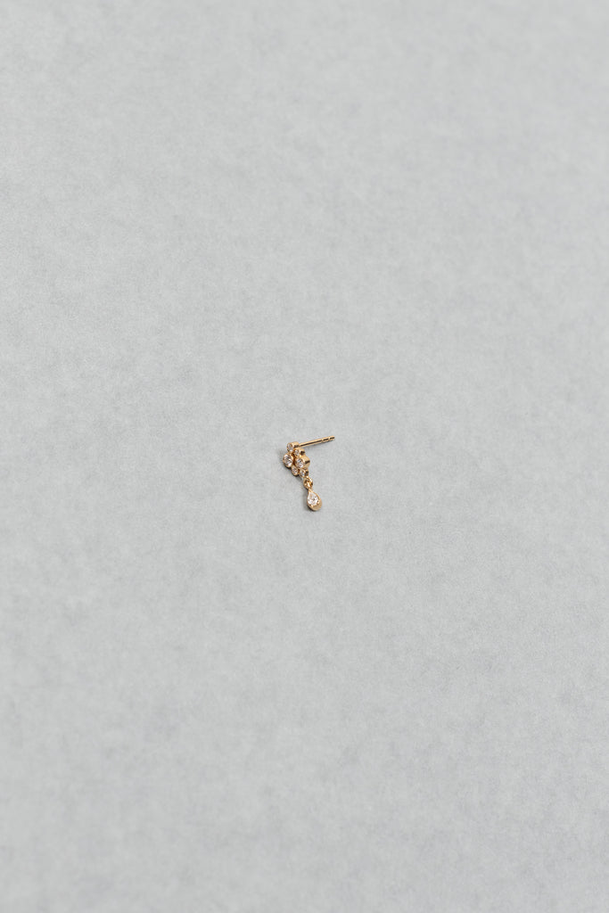 The Petite Splash Earring by Sophie Bille Brahe is a delicate and dainty earring designed to emulate the splashing of water with diamonds varying in size and a pear shaped diamond drop