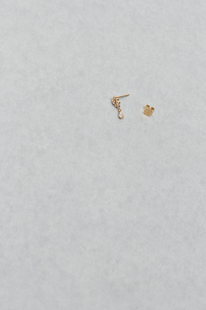 The Petite Splash Earring by Sophie Bille Brahe is a delicate and dainty earring designed to emulate the splashing of water with diamonds varying in size and a pear shaped diamond drop