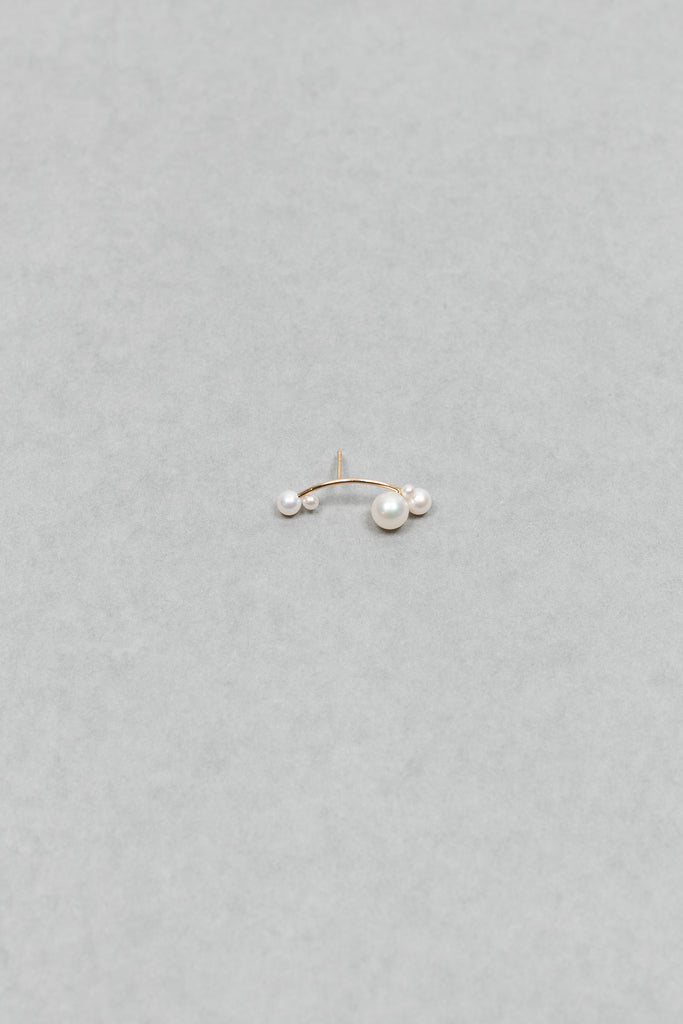 The Stellari Right by Sophie Bille Brahe is a petite version of the Stellari Perle earring with pearls in various sizes placed on a curved gold stem