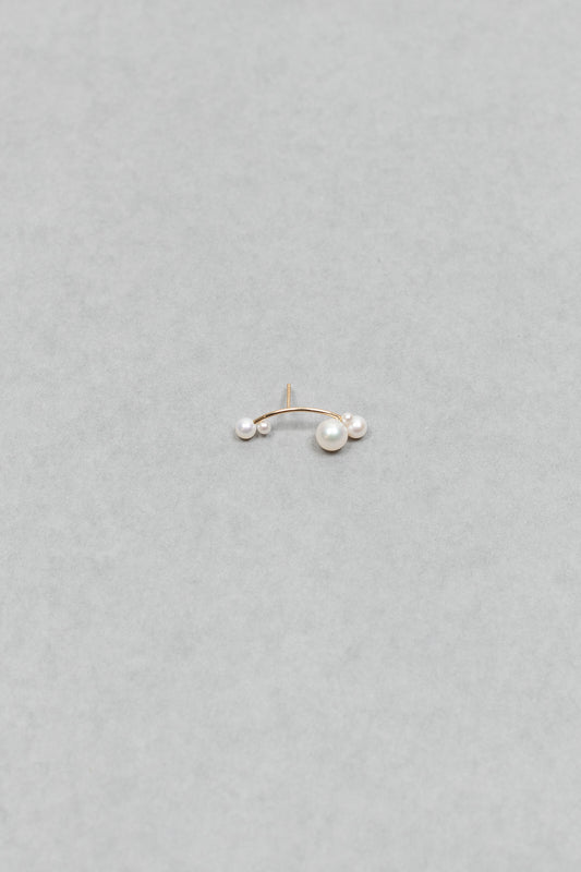 The Stellari Right by Sophie Bille Brahe is a petite version of the Stellari Perle earring with pearls in various sizes placed on a curved gold stem