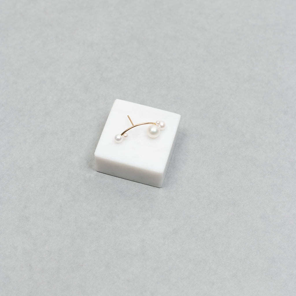 The Stellari Right by Sophie Bille Brahe is a petite version of the Stellari Perle earring with pearls in various sizes placed on a curved gold stem